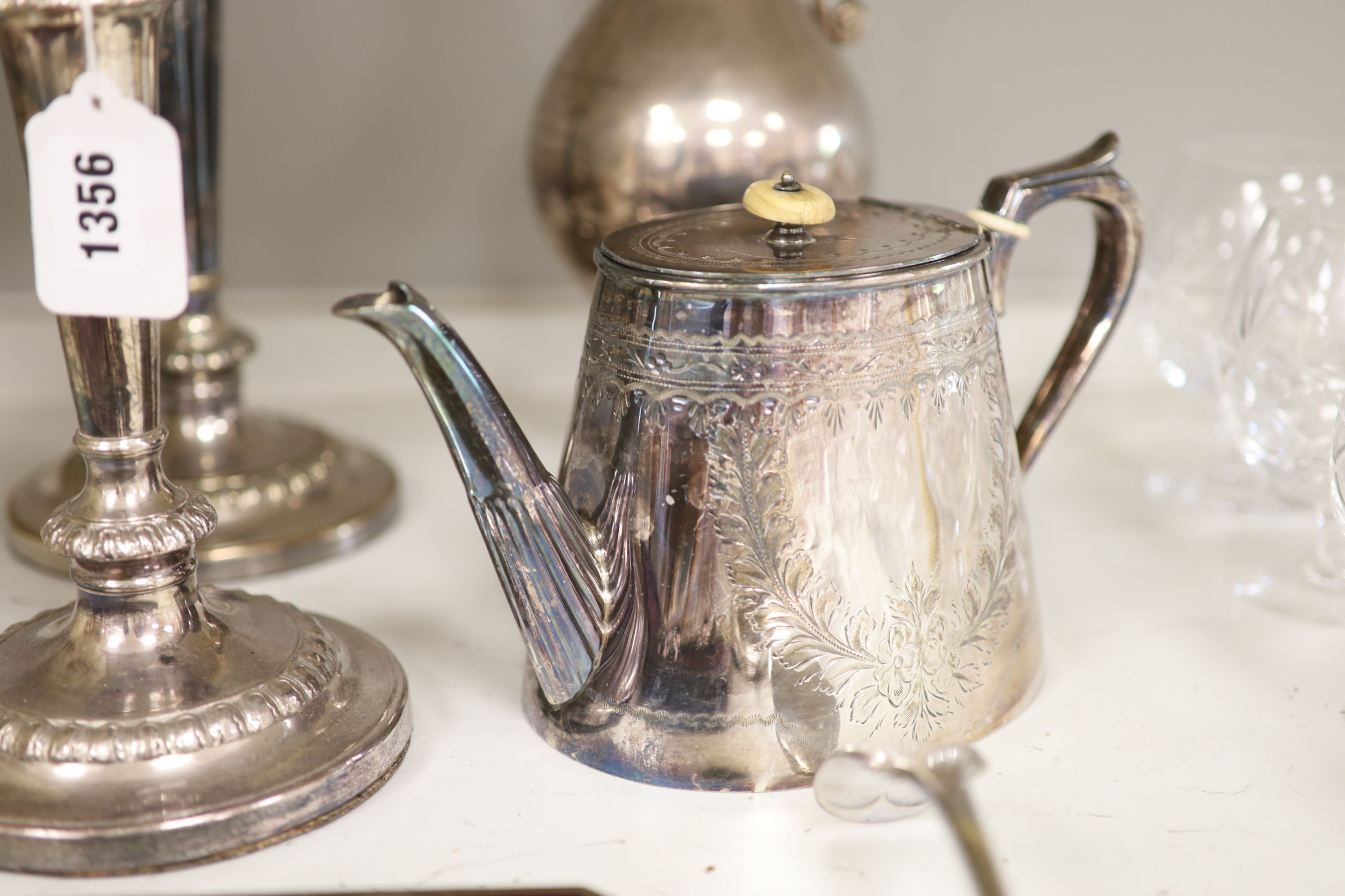 A pair of plated candlesticks, a wine ewer, height 33cm (dented), teapot, ladle, cased nutcrackers